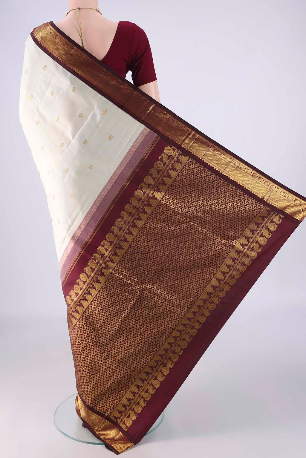 Flat view of Off White Kanchipuram Silk Saree with Zari Butta on the body and Zari Border. 
