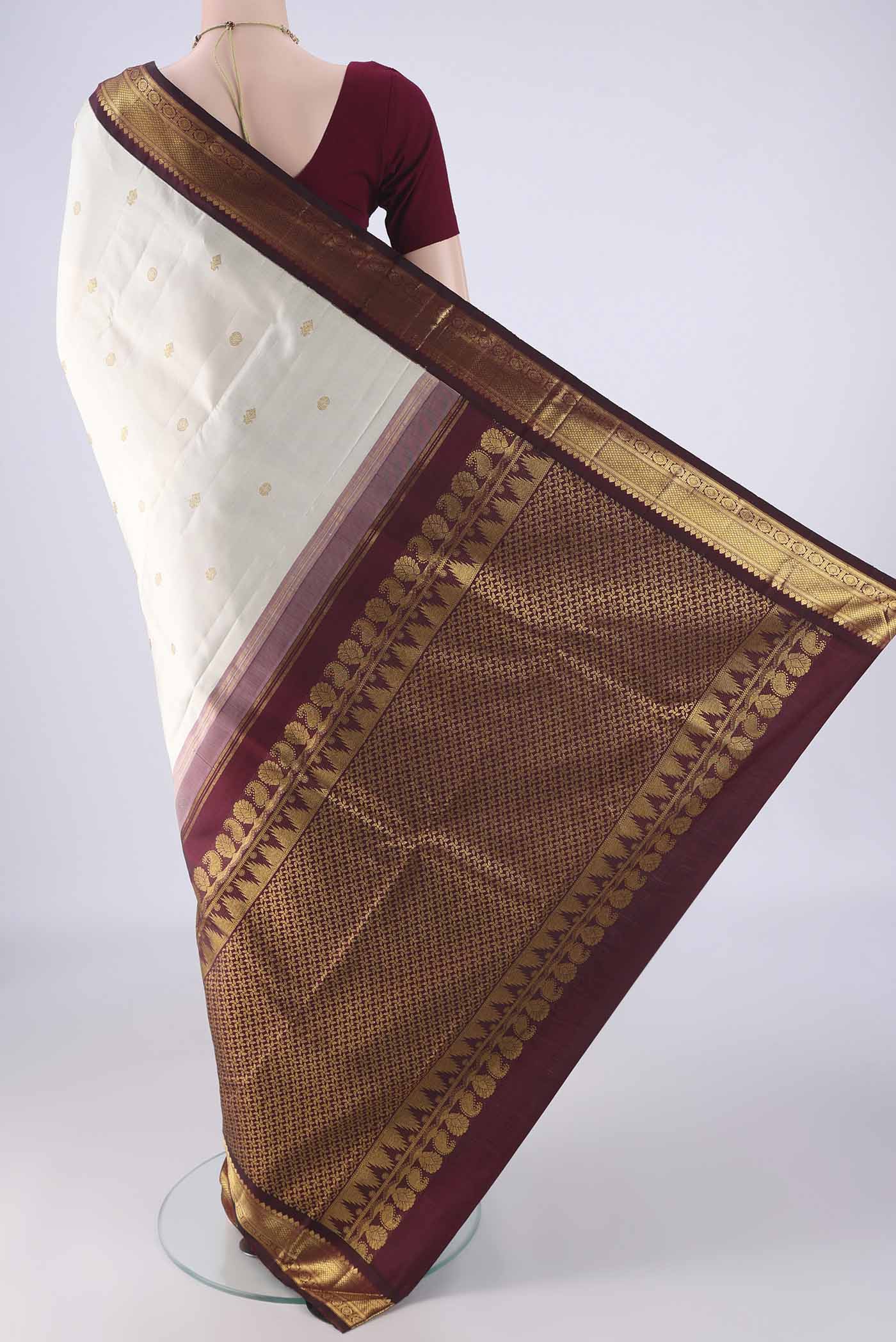 Flat view of Off White Kanchipuram Silk Saree with Zari Butta on the body and Zari Border. 