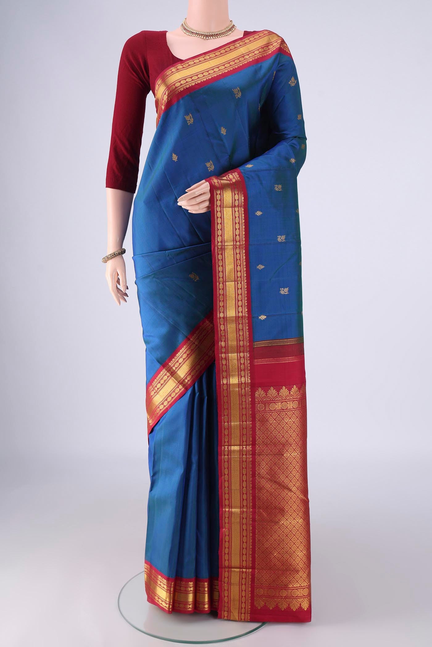 Blue Kanchipuram Silk Saree with Zari Butta on the body and Zari Border.  displayed on a mannequin
