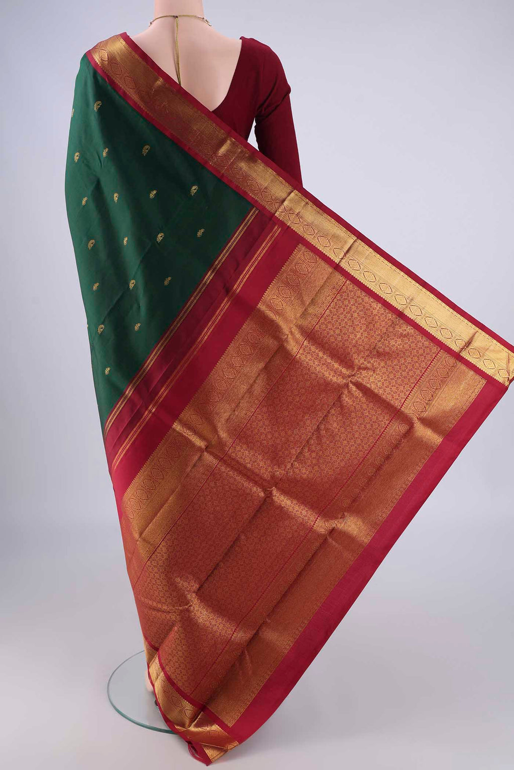 Flat view of Bottle Green Kanchipuram Silk Saree with Zari Butta on the body and Zari Border. 