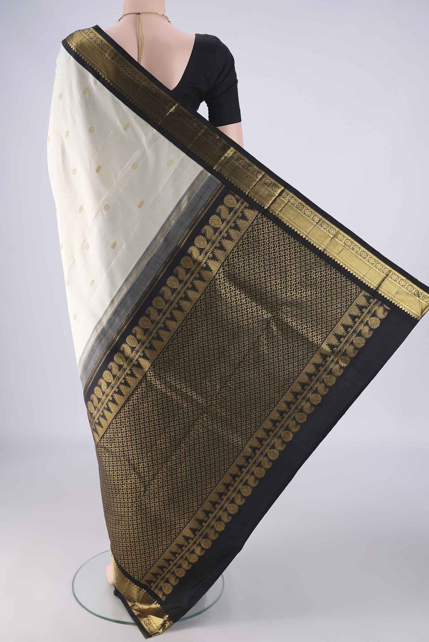 Flat view of Off White Kanchipuram Silk Saree with Zari Butta on the body and Zari Border. 