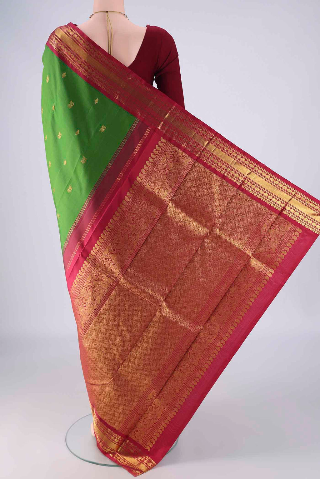 Flat view of Green Kanchipuram Silk Saree with Zari Butta on the body and Zari Border. 