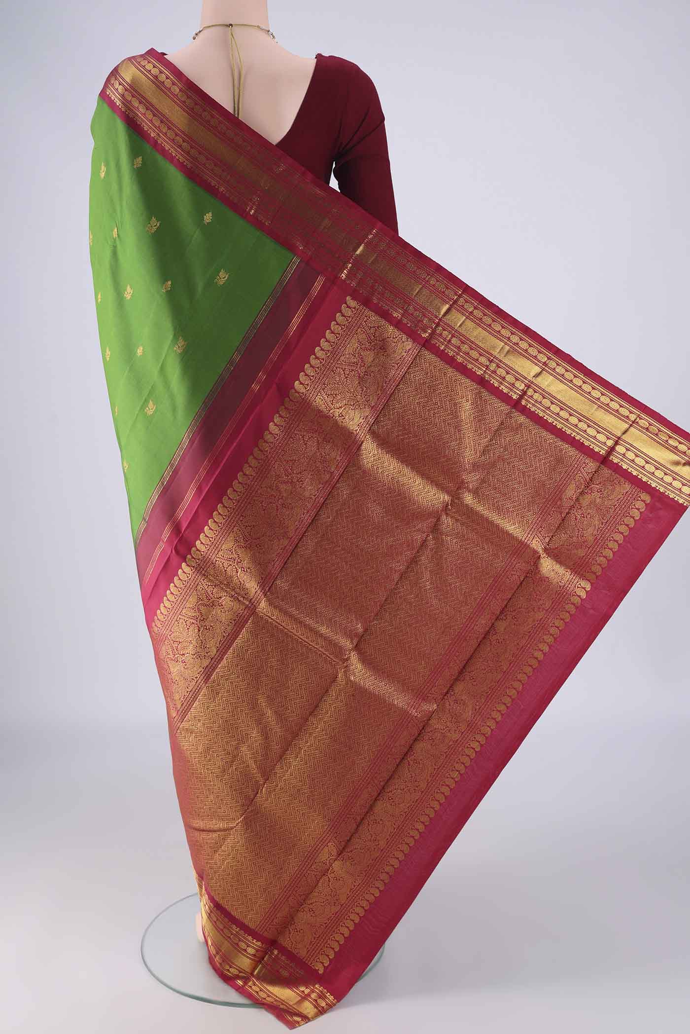 Flat view of Green Kanchipuram Silk Saree with Zari Butta on the body and Zari Border. 