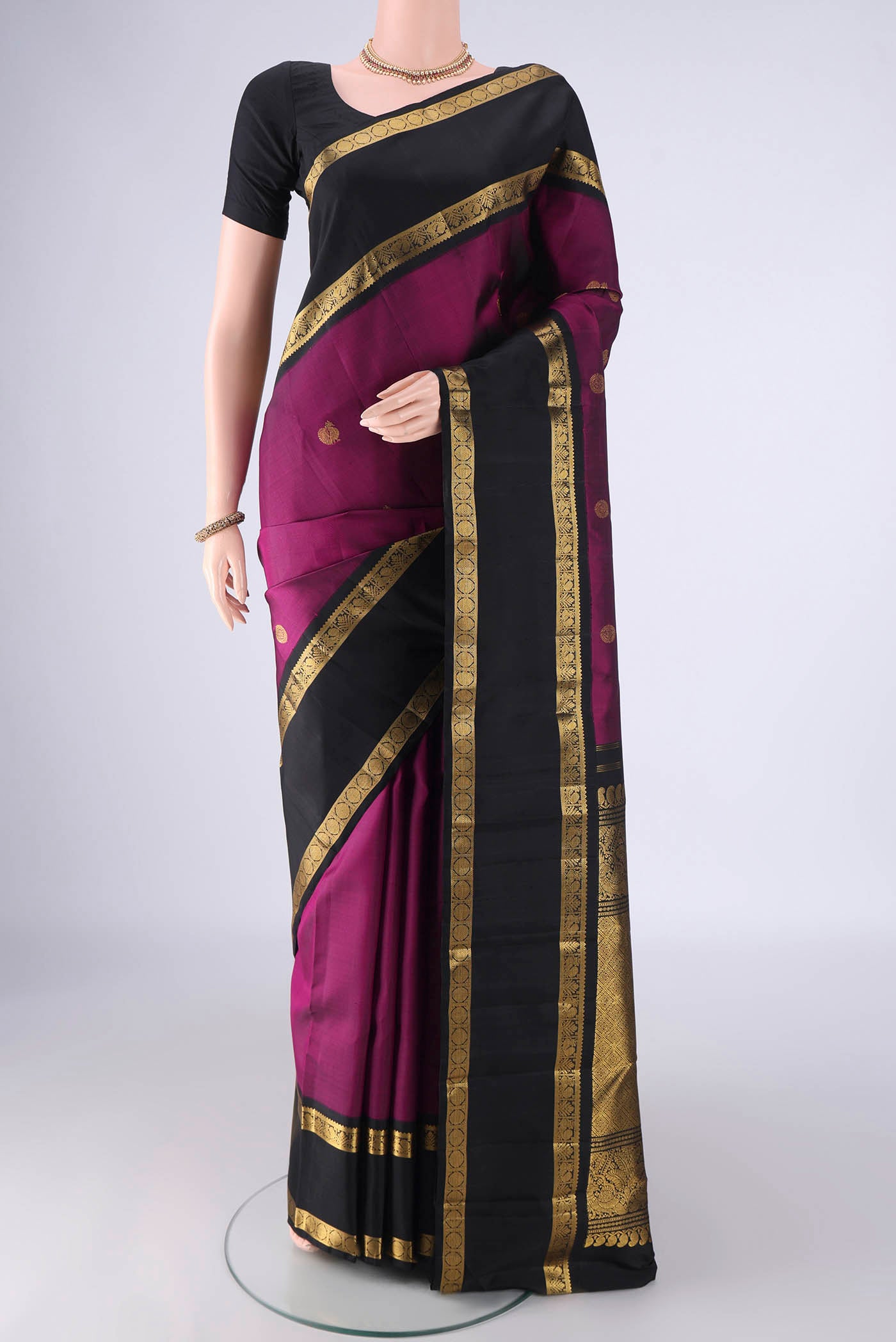 Magenta Kanchipuram Silk Saree with Zari Butta on the body and Zari Border.  displayed on a mannequin