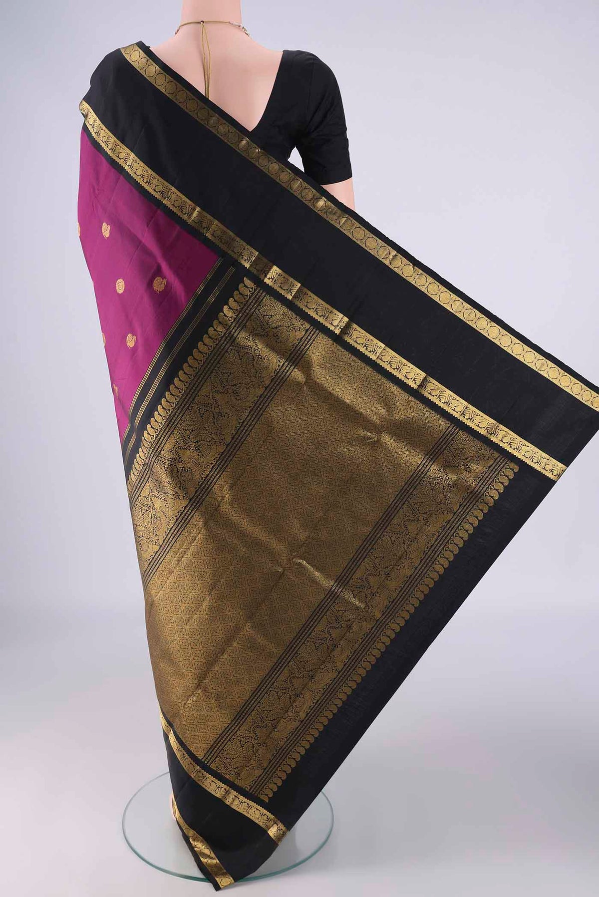 Flat view of Magenta Kanchipuram Silk Saree with Zari Butta on the body and Zari Border. 