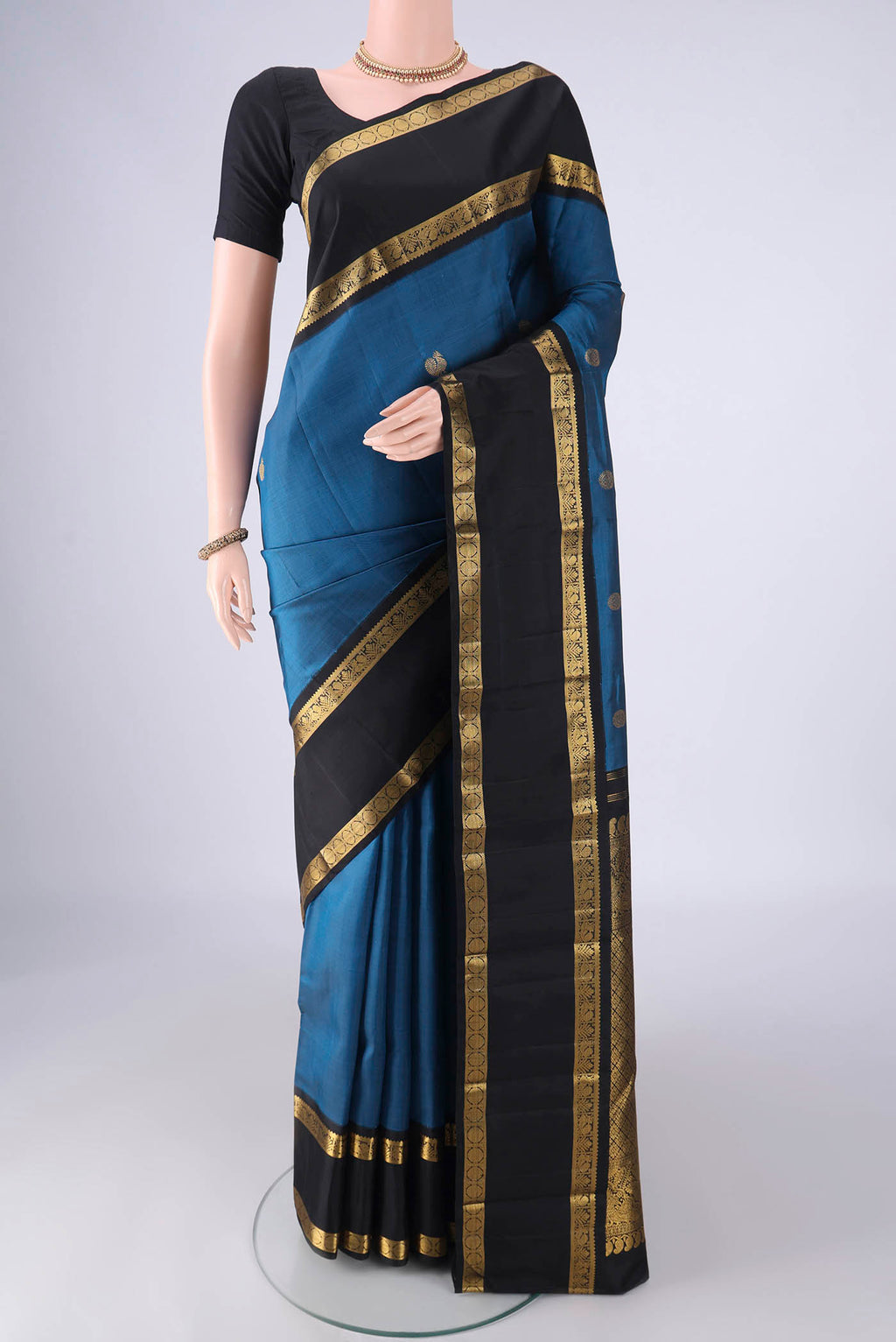 Blue Kanchipuram Silk Saree with Zari Butta on the body and Zari Border.  displayed on a mannequin