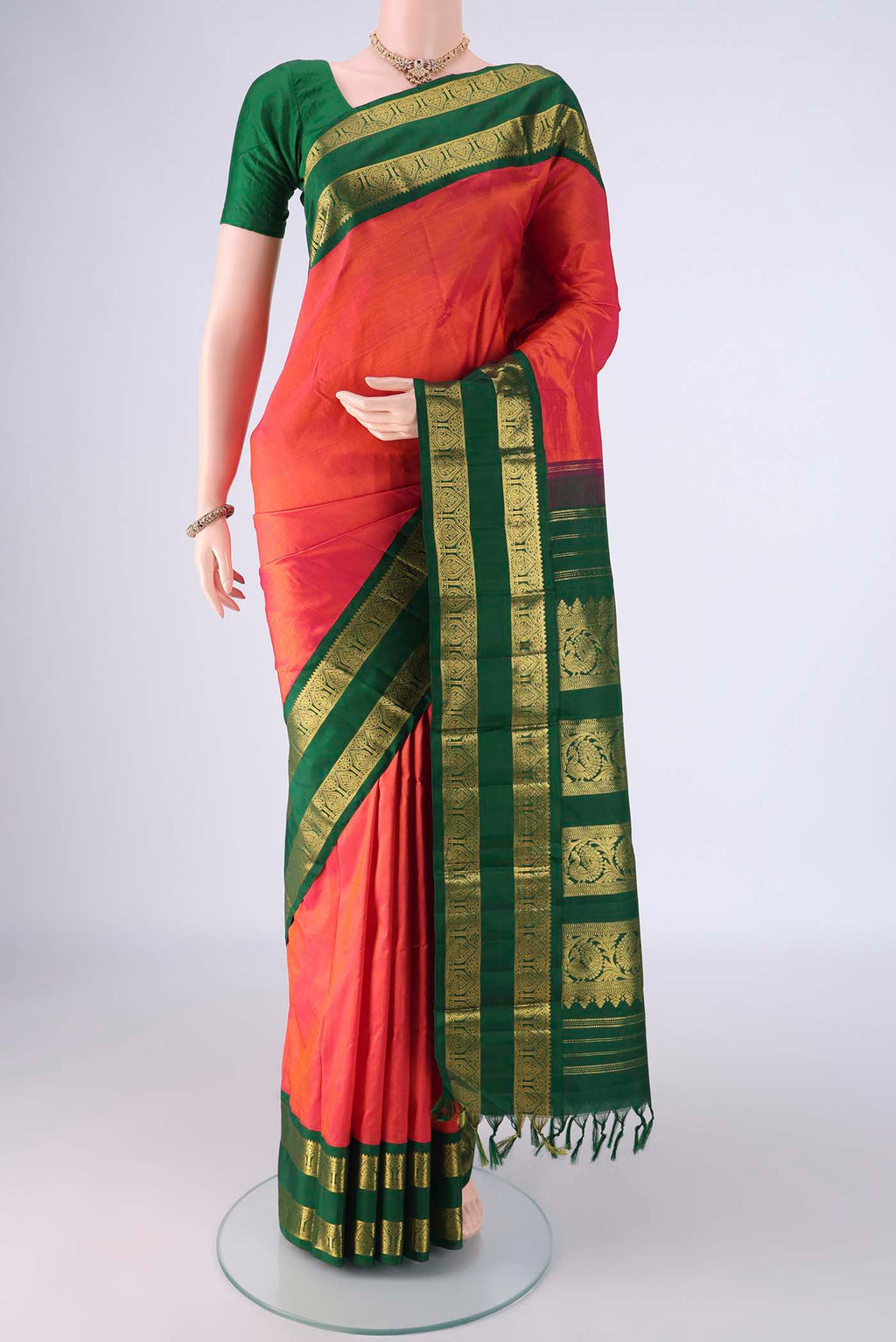 Brick Orange Kanjivaram Silk Saree with Plain Body and Zari Border.  displayed on a mannequin