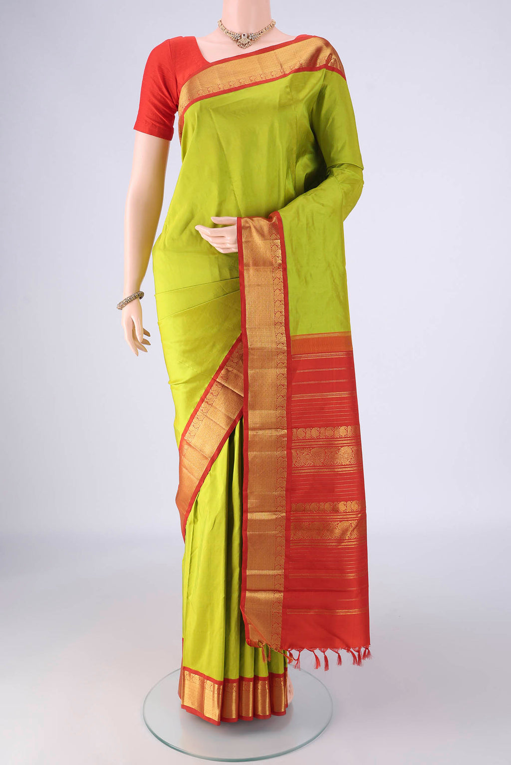 Parrot Green Kanjivaram Silk Saree with Plain Body and Zari Border.  displayed on a mannequin