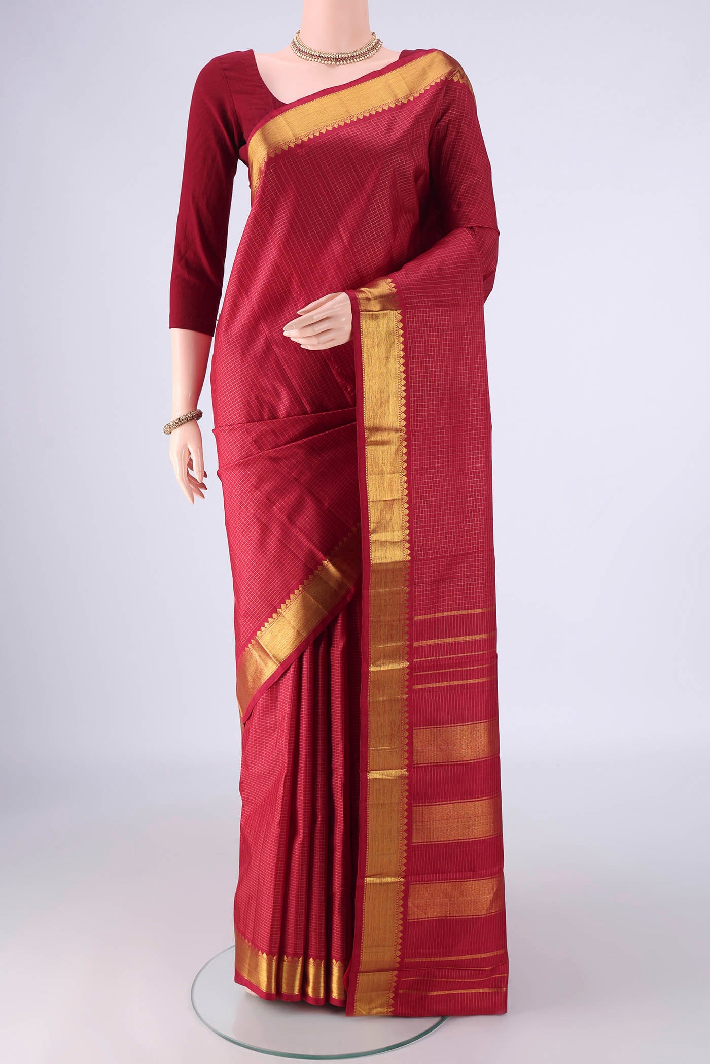 Deep Red Kanchipuram Silk Saree with Checked design on the body and Zari Border.  displayed on a mannequin