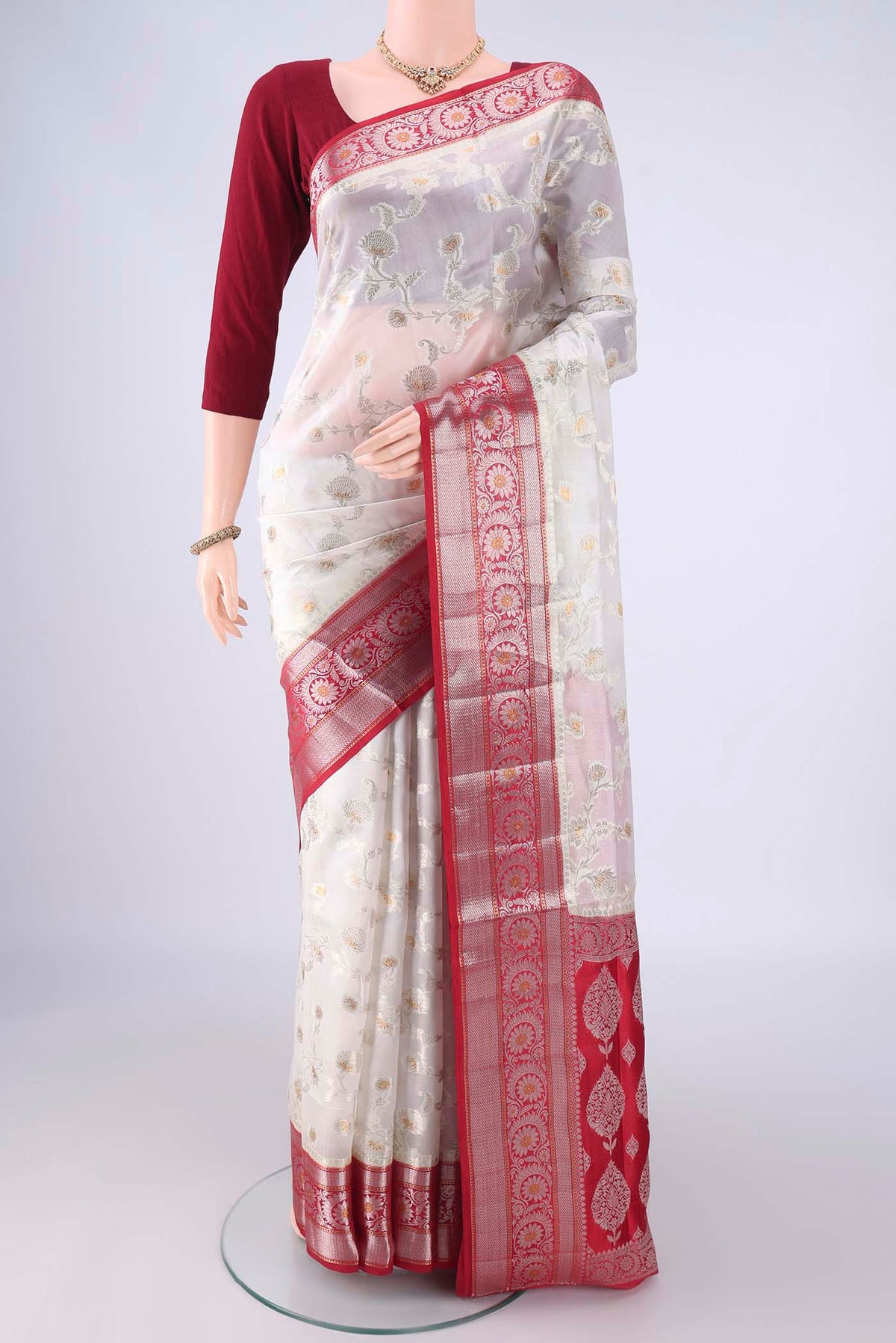 Pearl White Banarasi Raw Silk Saree with Zari Brocade on the body and Zari Border.  displayed on a mannequin