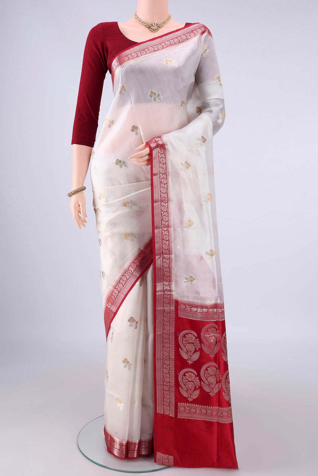 Pure Silk White Banarasi Raw Saree with Zari Butta on the body and Zari Border.  displayed on a mannequin