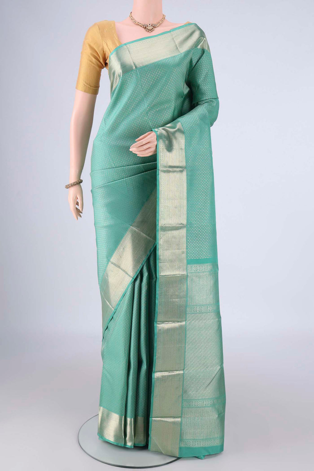 Light Green Kanchipuram Silk Saree with Zari Brocade on the body and Zari Border.  displayed on a mannequin