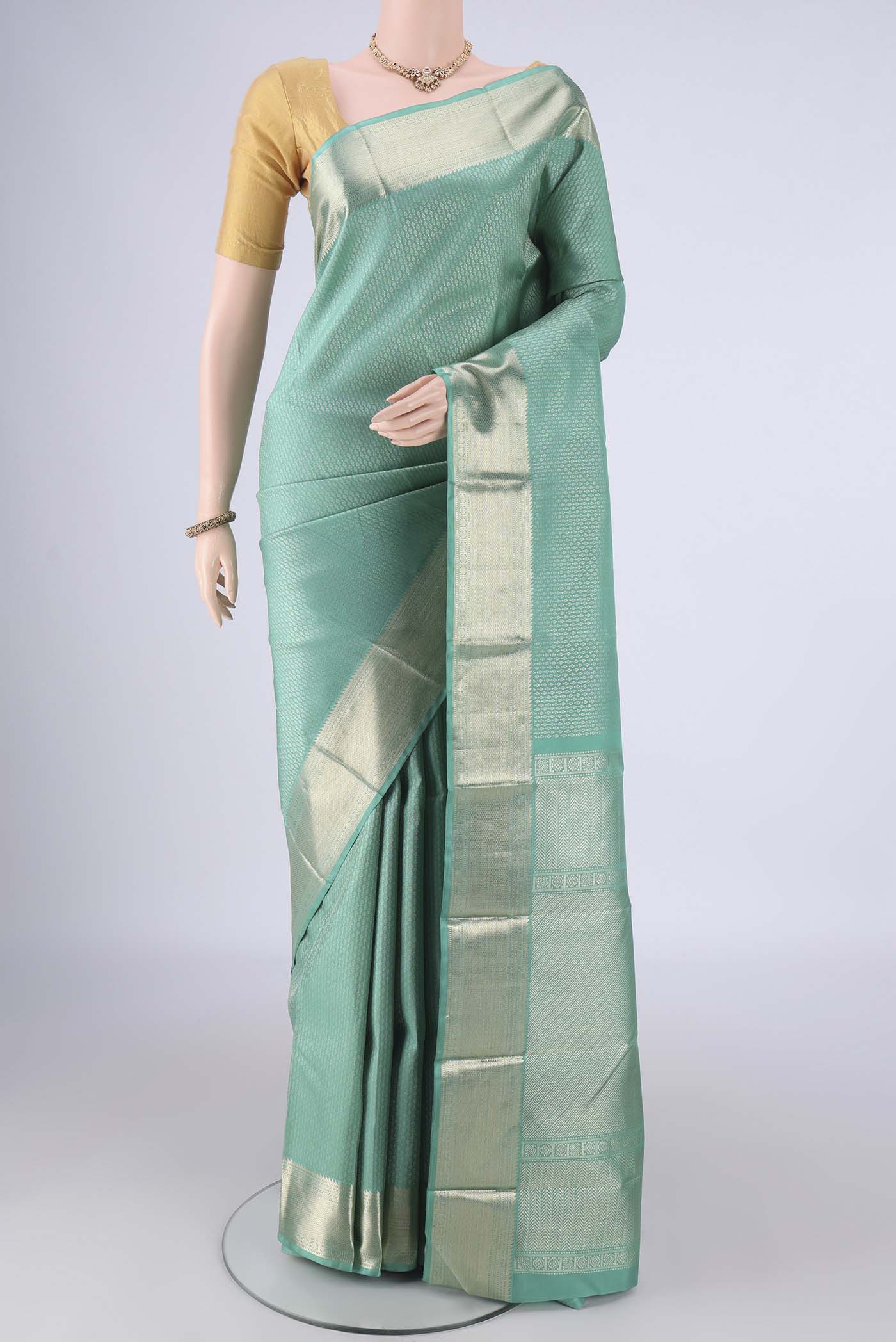 Light Green Kanchipuram Silk Saree with Zari Brocade on the body and Zari Border.  displayed on a mannequin