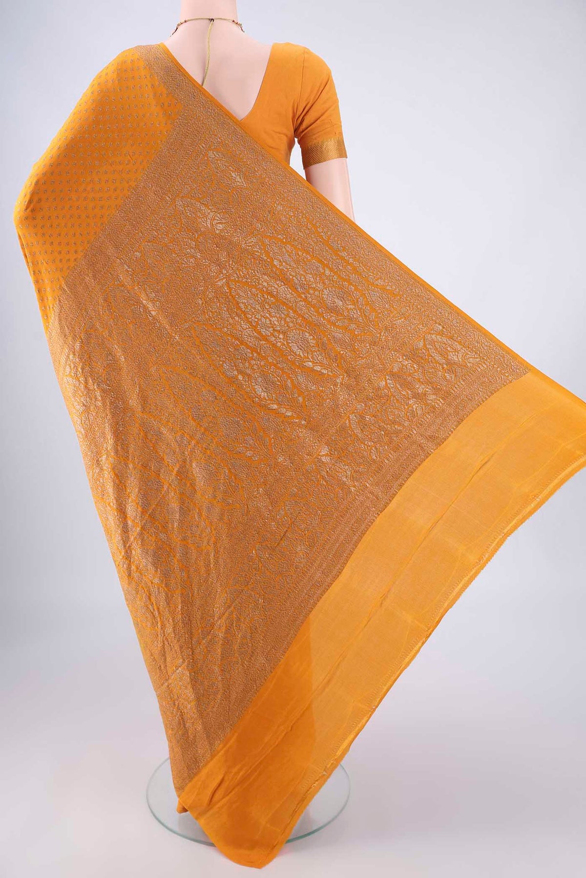 Flat view of Mustard Banarasi Georgette Saree with Zari Butta on the body and Zari Border. 