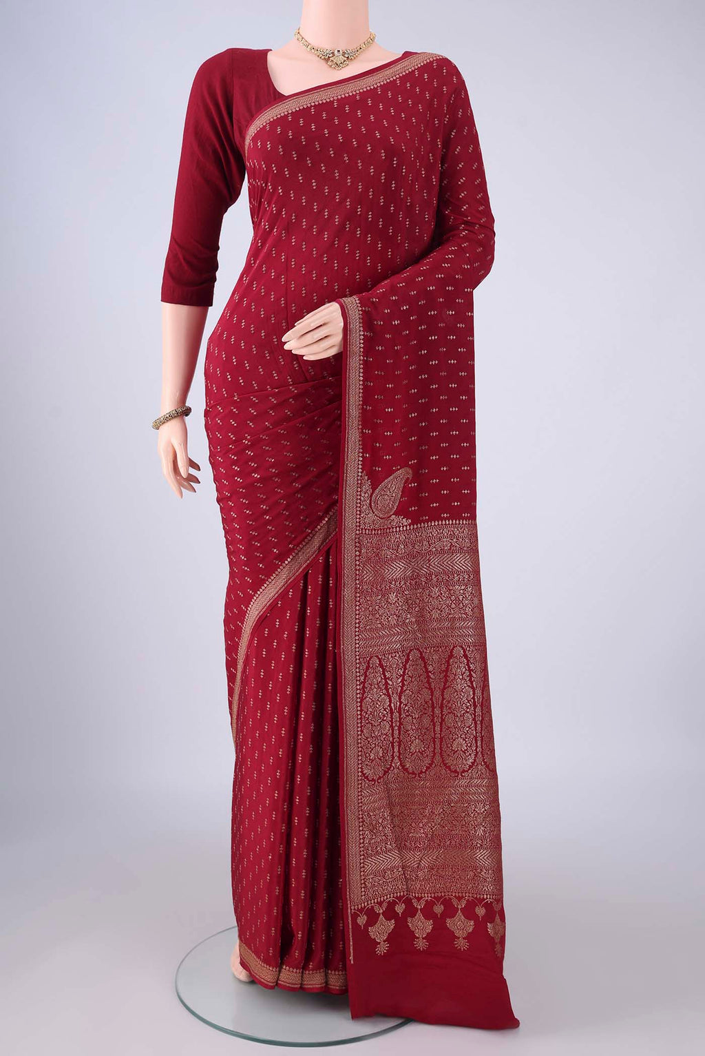 Maroon Banarasi Georgette Saree with Zari Butta on the body and Zari Border.  displayed on a mannequin