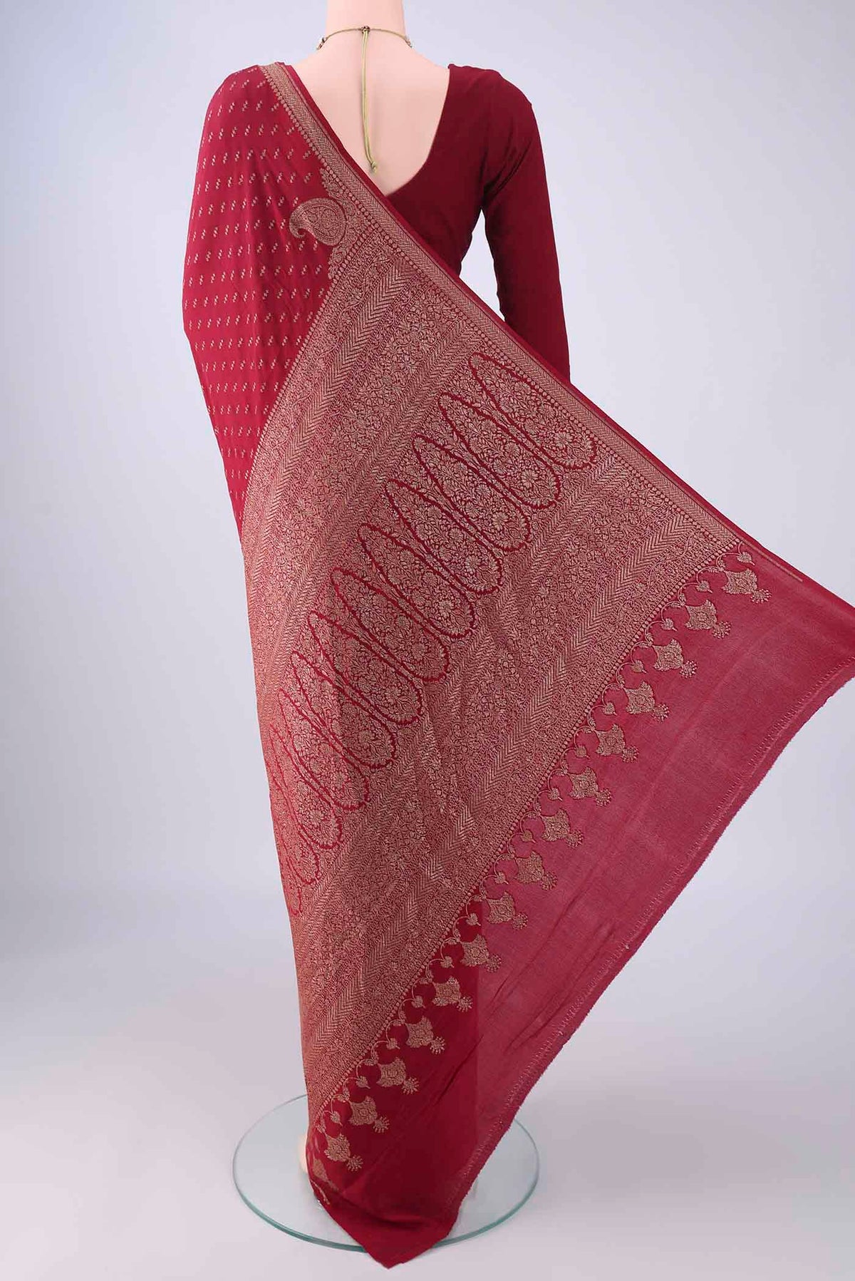 Flat view of Maroon Banarasi Georgette Saree with Zari Butta on the body and Zari Border. 