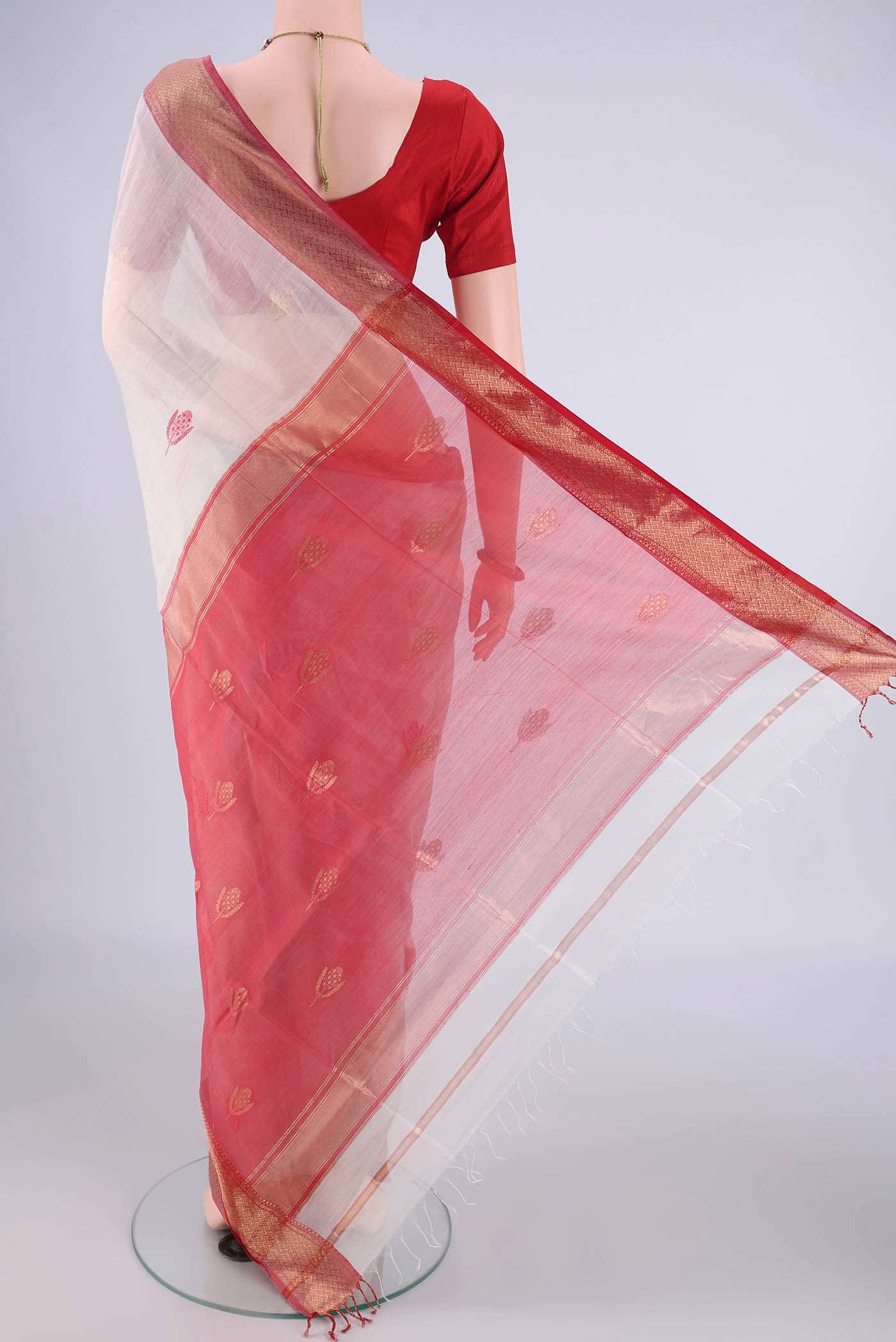 Flat view of White Maheshwari Silk Cotton Saree with Thread Butta on the body and Zari Border. 