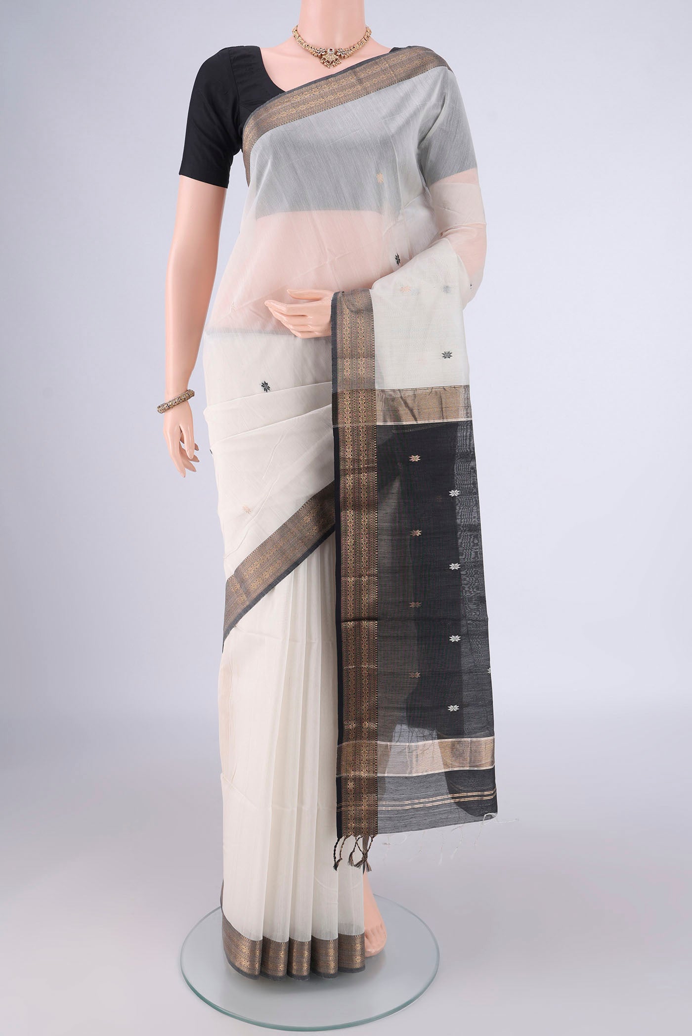 White Maheshwari Silk Cotton Saree with Thread Butta on the body and Zari Border.  displayed on a mannequin