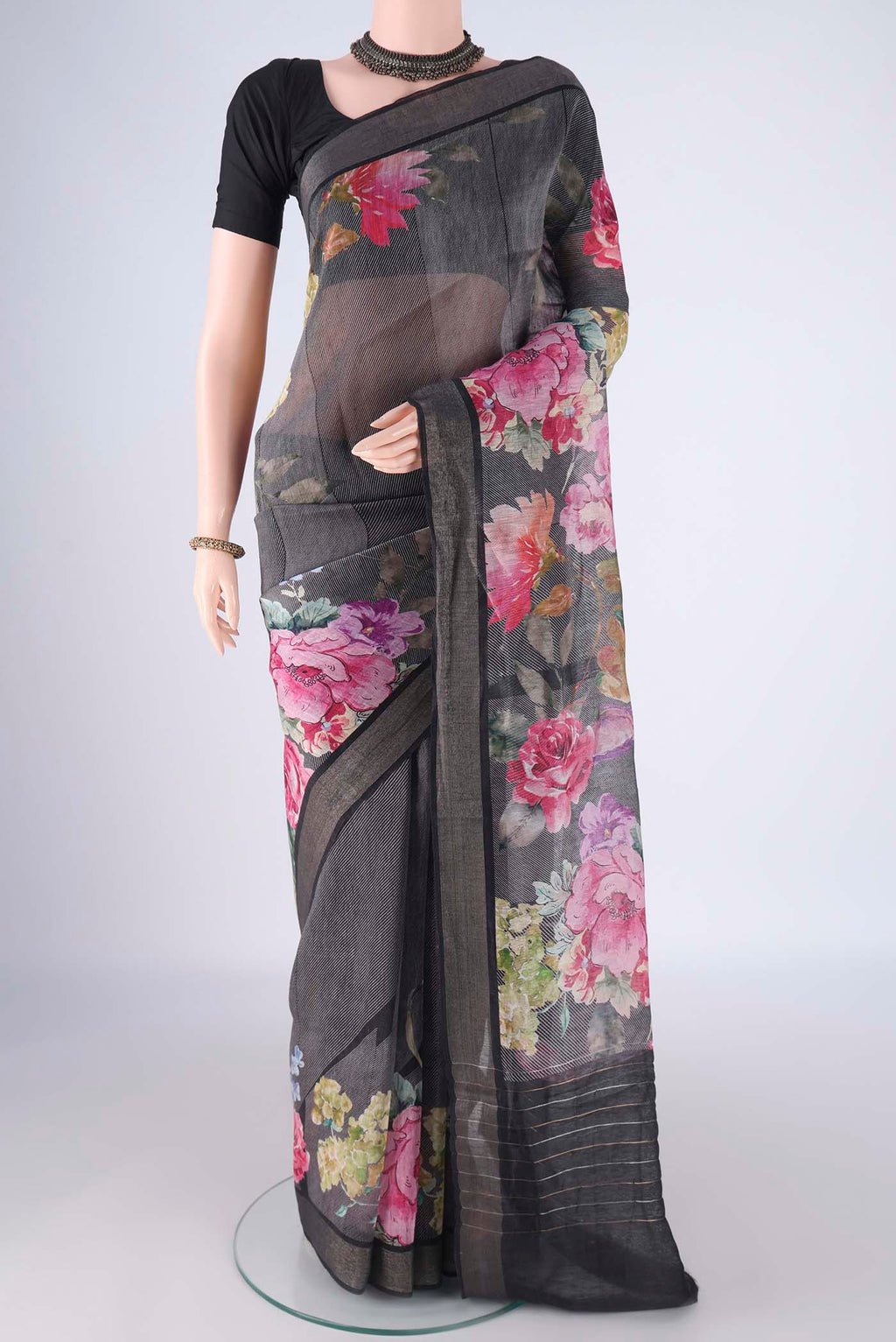 Black Linen Saree with Printed design on the body and Zari Border.  displayed on a mannequin
