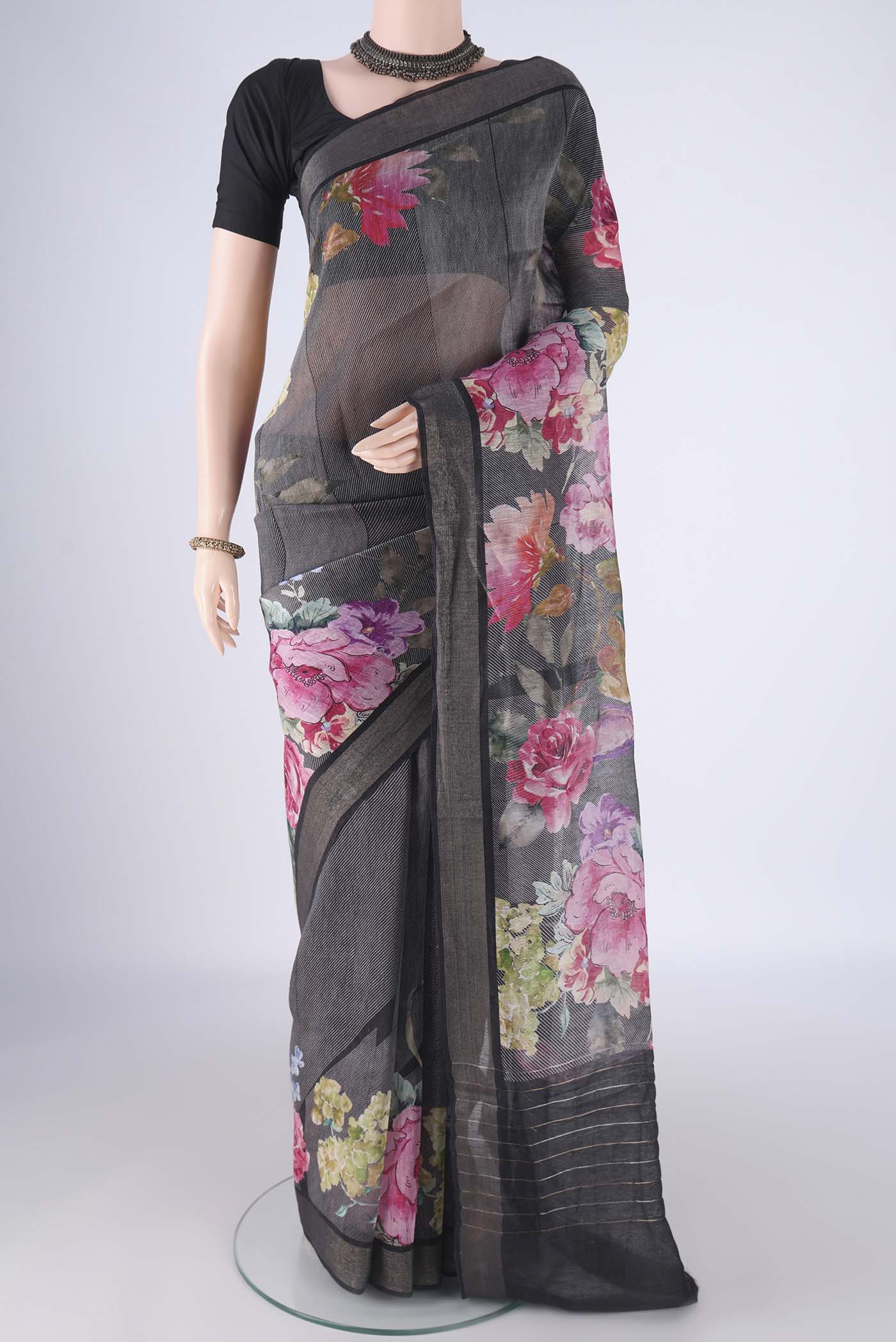 Black Linen Saree with Printed design on the body and Zari Border.  displayed on a mannequin