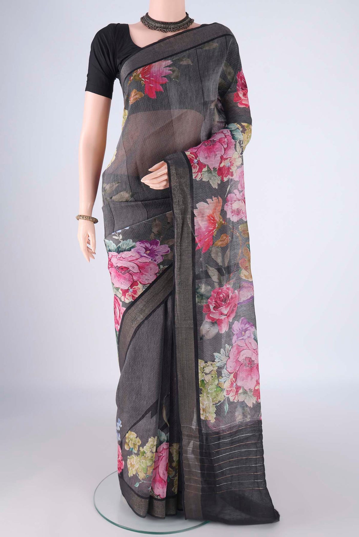 Black Linen Saree with Printed design on the body and Zari Border.  displayed on a mannequin