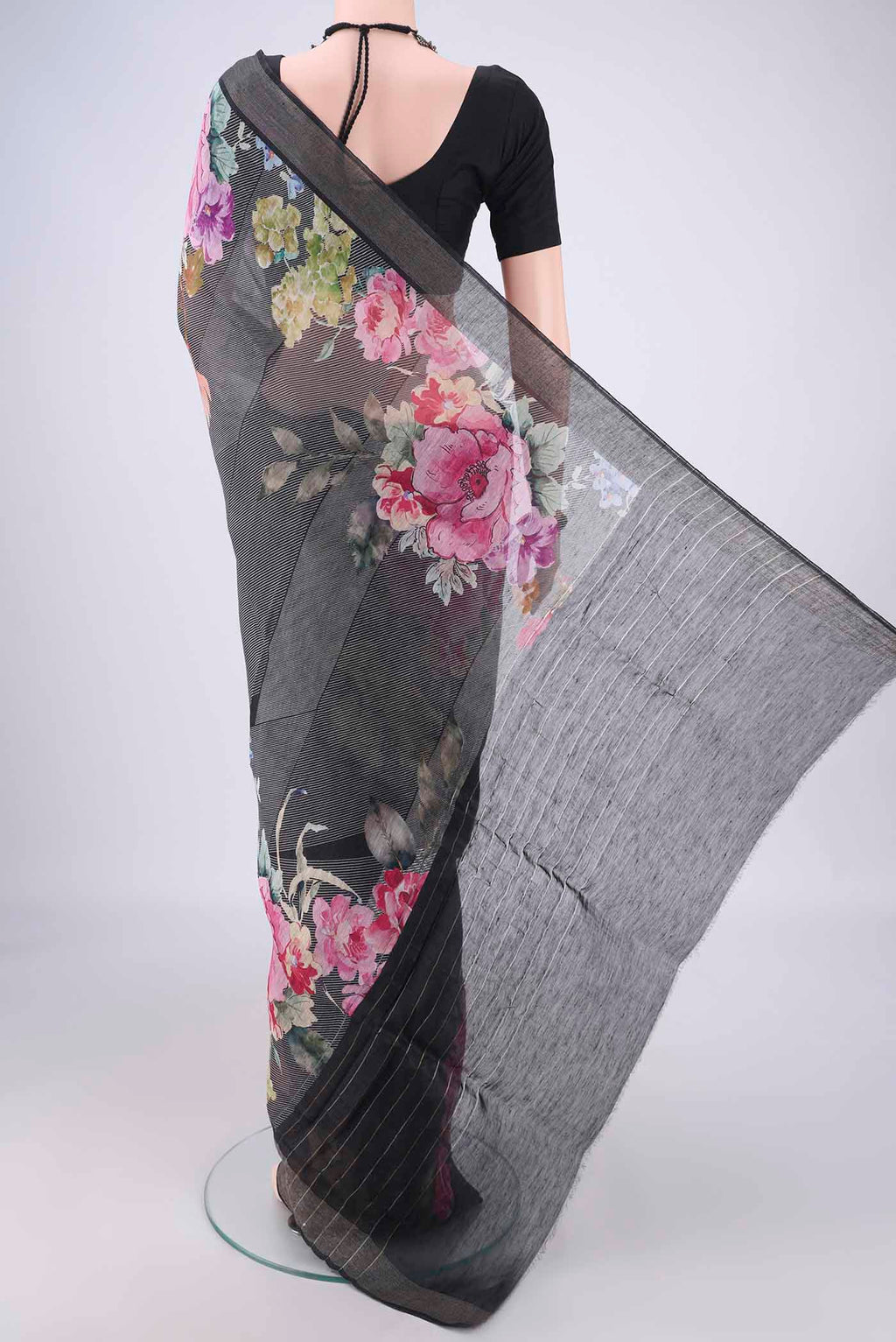 Flat view of Black Linen Saree with Printed design on the body and Zari Border. 