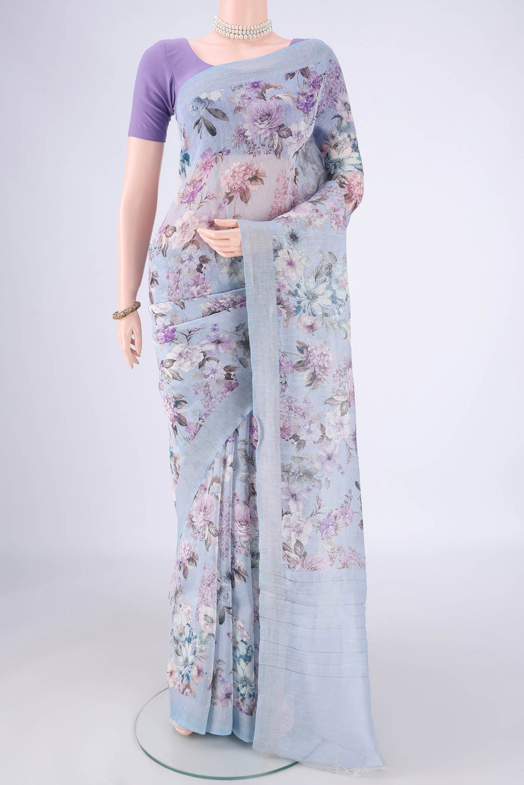 Sky Blue Linen Saree with Printed design on the body and Zari Border.  displayed on a mannequin