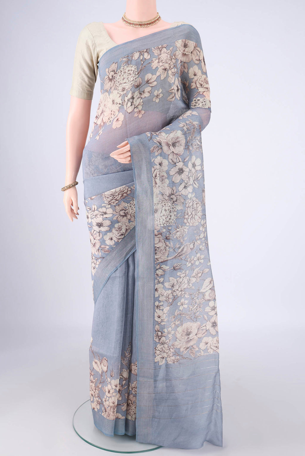 Blue Grey Linen Saree with Printed design on the body and Zari Border.  displayed on a mannequin
