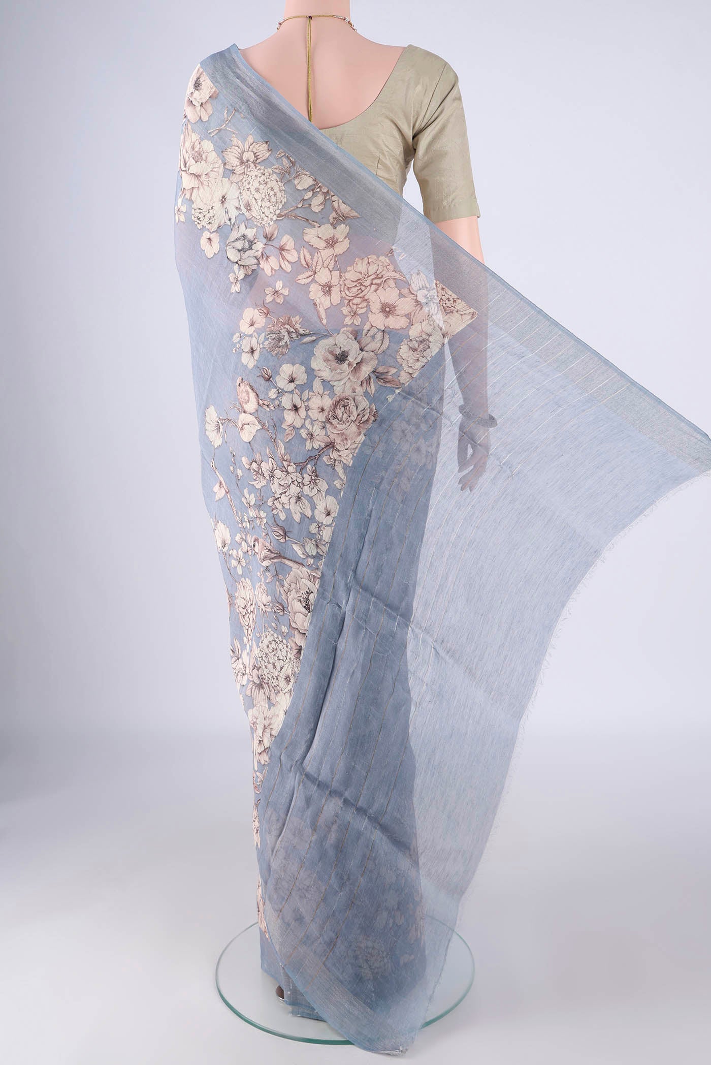 Flat view of Blue Grey Linen Saree with Printed design on the body and Zari Border. 