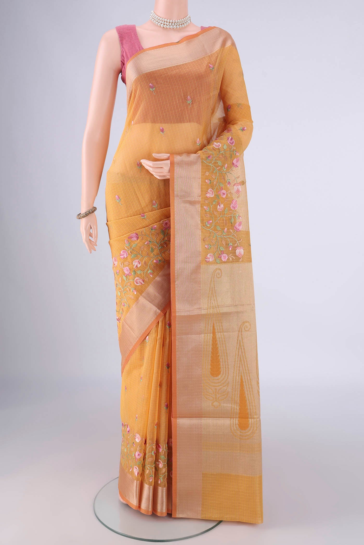 Mustard Kota Cotton Saree with Embroidery on the body and Zari Border.  displayed on a mannequin