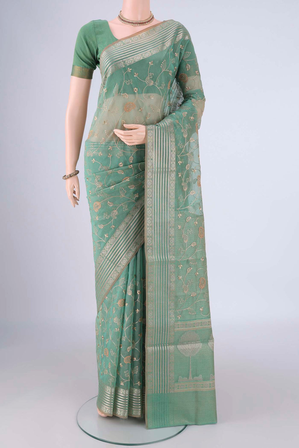 Light Green Blended Kota Cotton Saree with Embroidery on the body and Zari Border.  displayed on a mannequin