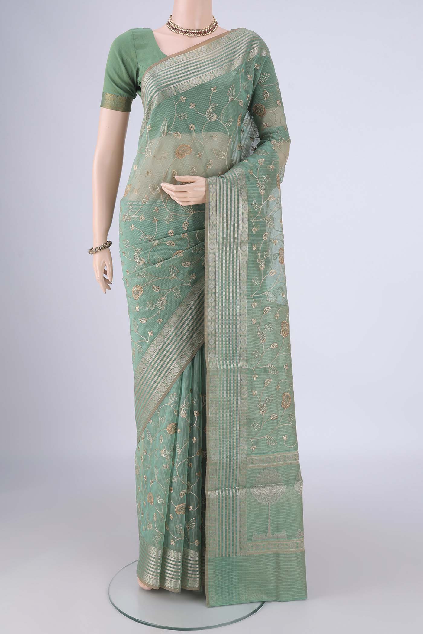 Light Green Blended Kota Cotton Saree with Embroidery on the body and Zari Border.  displayed on a mannequin