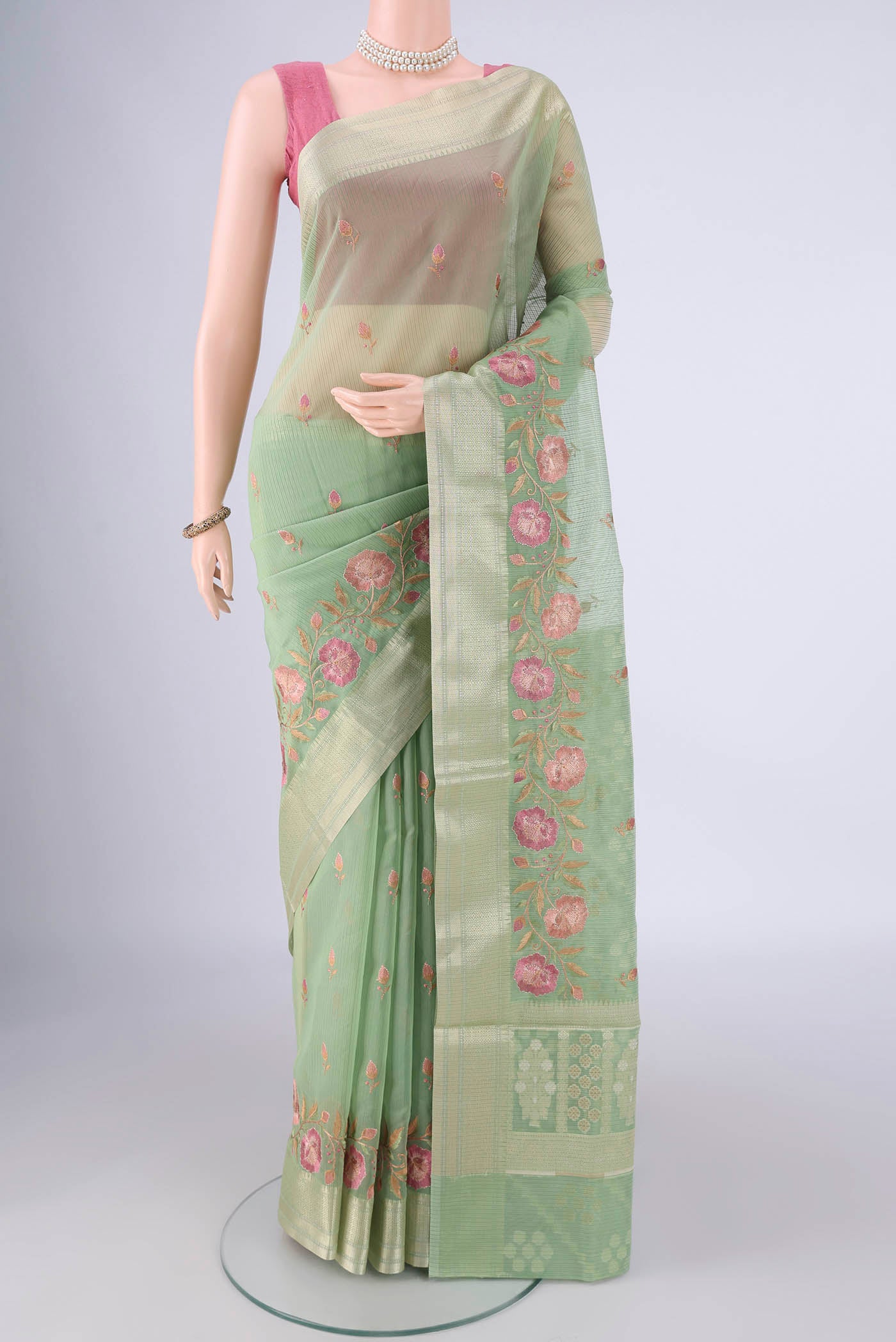 Light Green Blended Kota Cotton Saree with Embroidery on the body and Zari Border.  displayed on a mannequin
