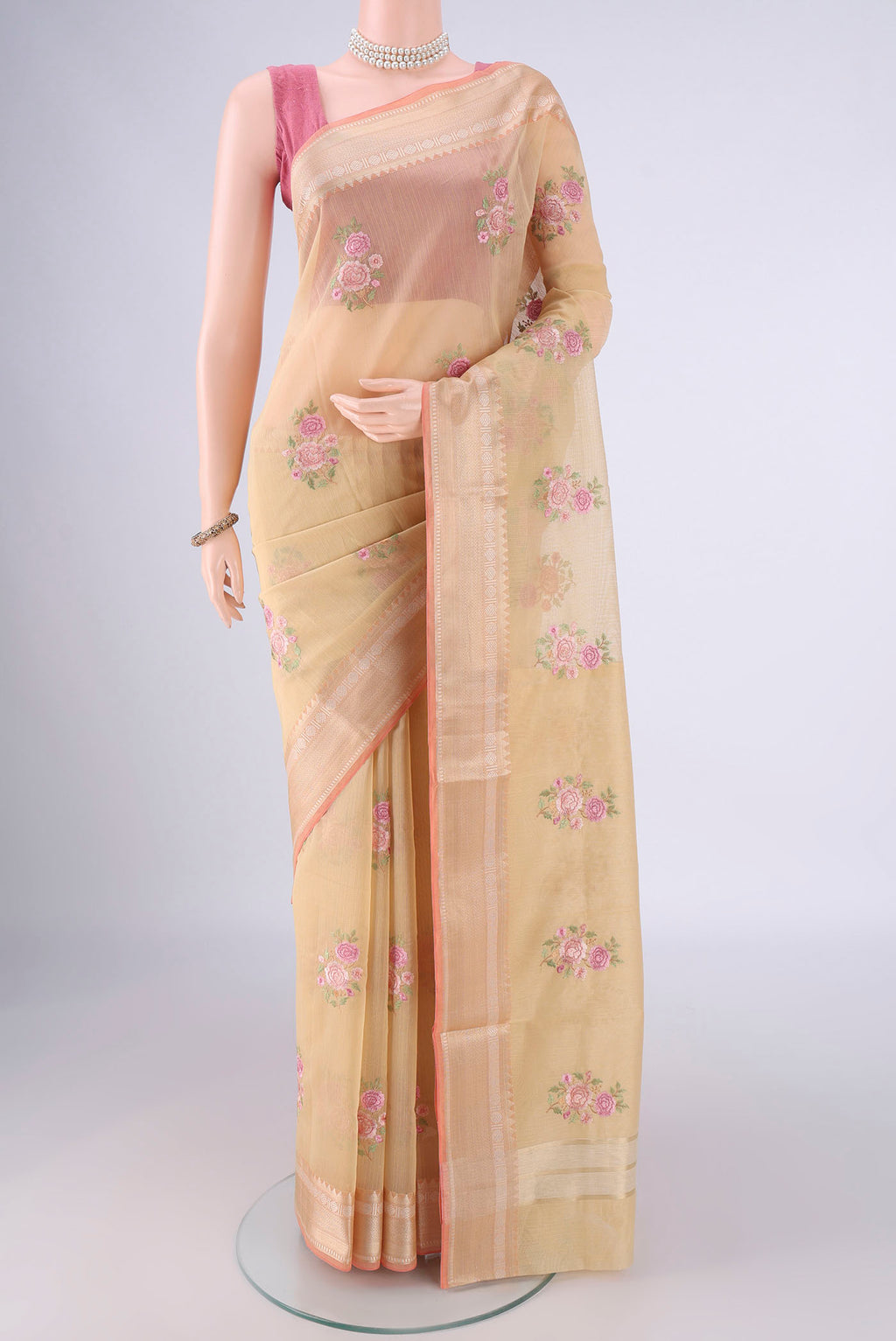 Beige Blended Kota Cotton Saree with Embroidery on the body and Zari Border.  displayed on a mannequin