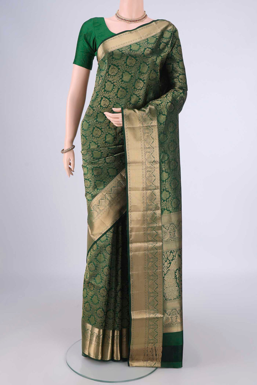 Bottle Green Soft Silk Saree with Zari Brocade on the body and Zari Border.  displayed on a mannequin