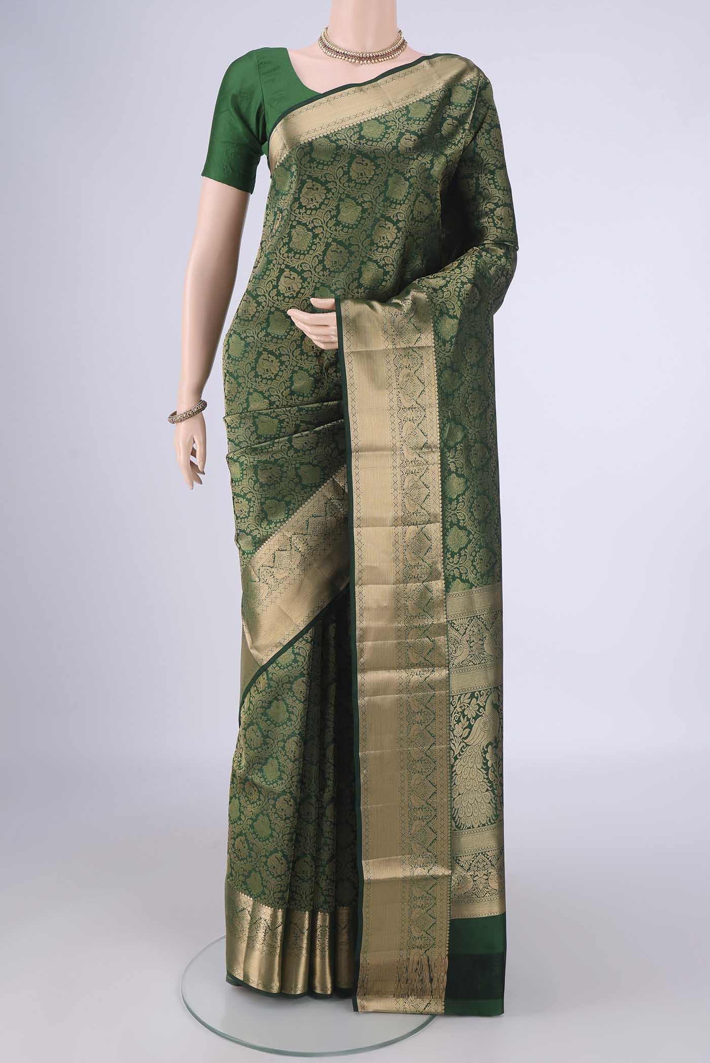 Bottle Green Soft Silk Saree with Zari Brocade on the body and Zari Border.  displayed on a mannequin