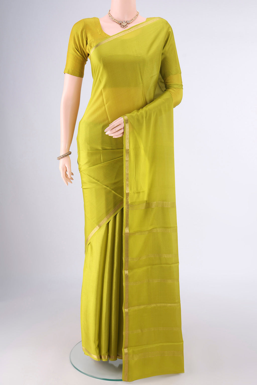 Parrot Green Mysore Crepe Saree with Plain Body and Zari Border.  displayed on a mannequin