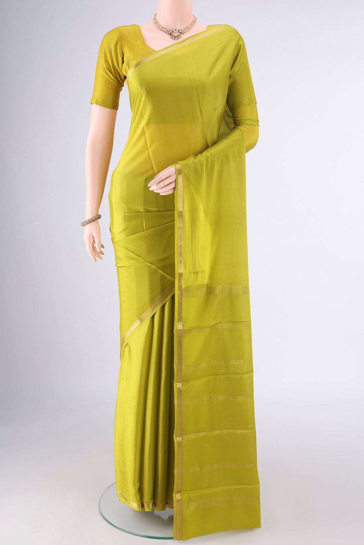 Parrot Green Mysore Crepe Saree with Plain Body and Zari Border.  displayed on a mannequin
