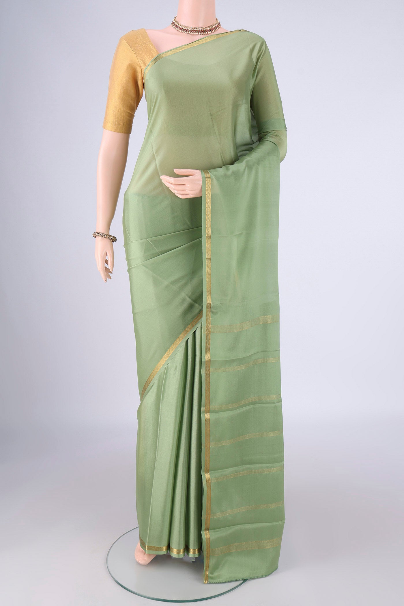 Pista Green Mysore Crepe Saree with Plain Body and Zari Border.  displayed on a mannequin