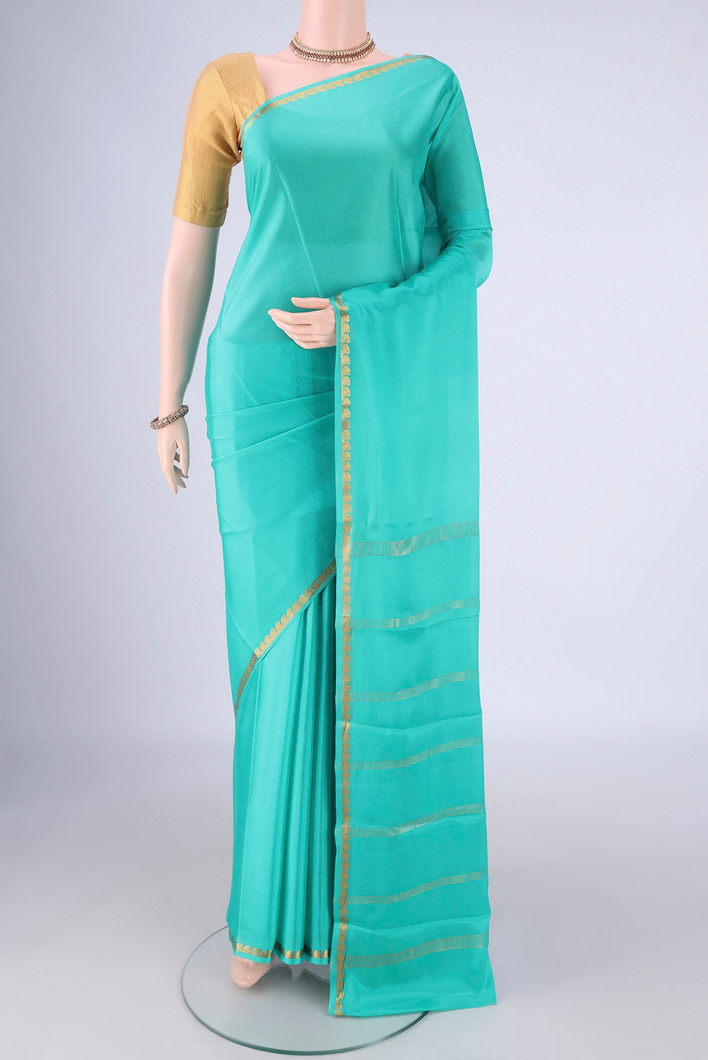 Turquoise Mysore Crepe Saree with Plain Body and Zari Border.  displayed on a mannequin
