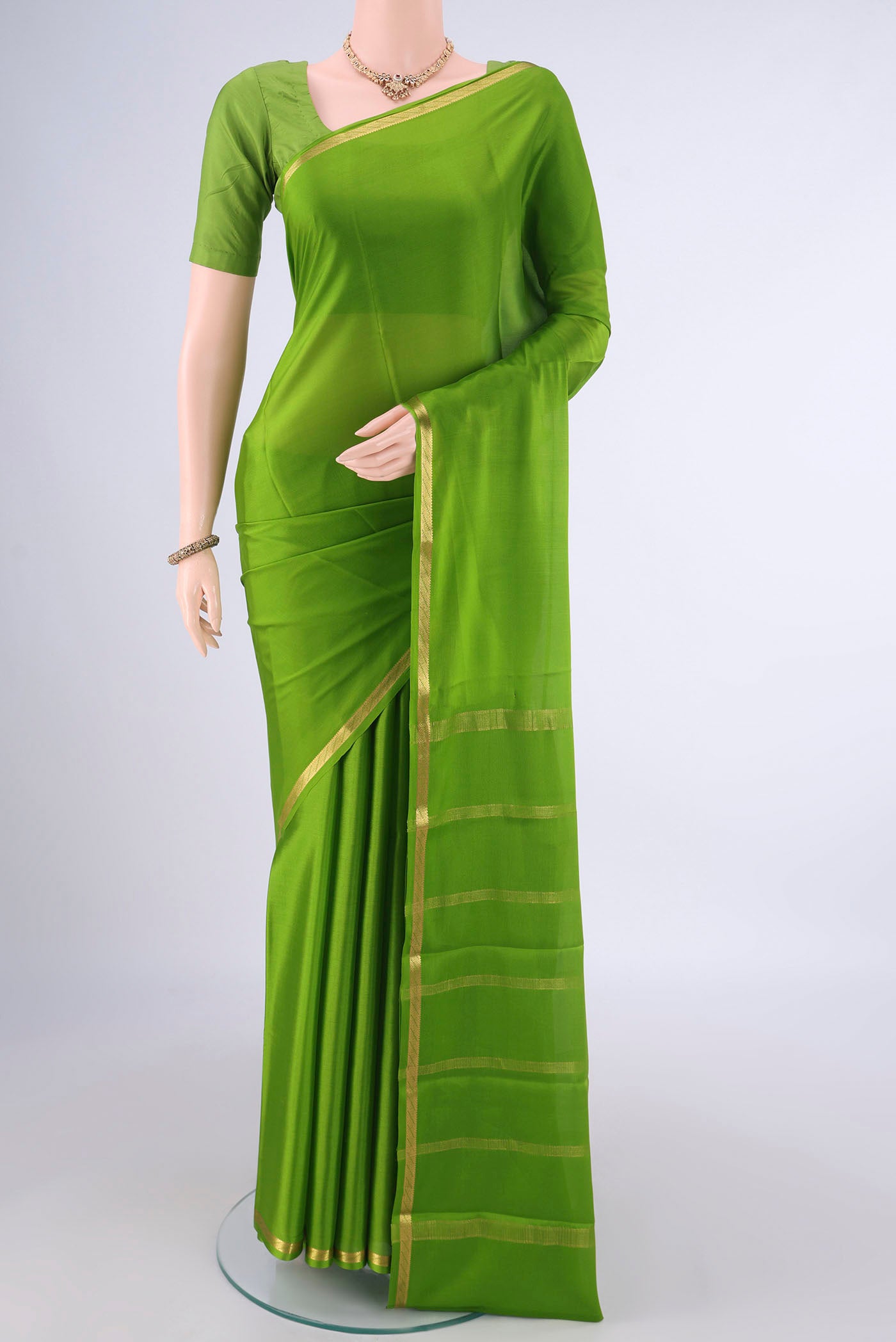 Green Mysore Crepe Saree with Plain Body and Zari Border.  displayed on a mannequin