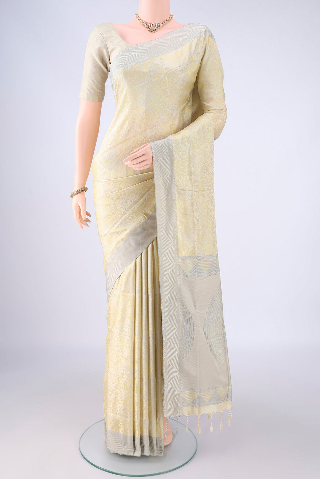 Cream Soft Silk Saree with Jacquard design on the body and Thread Border.  displayed on a mannequin