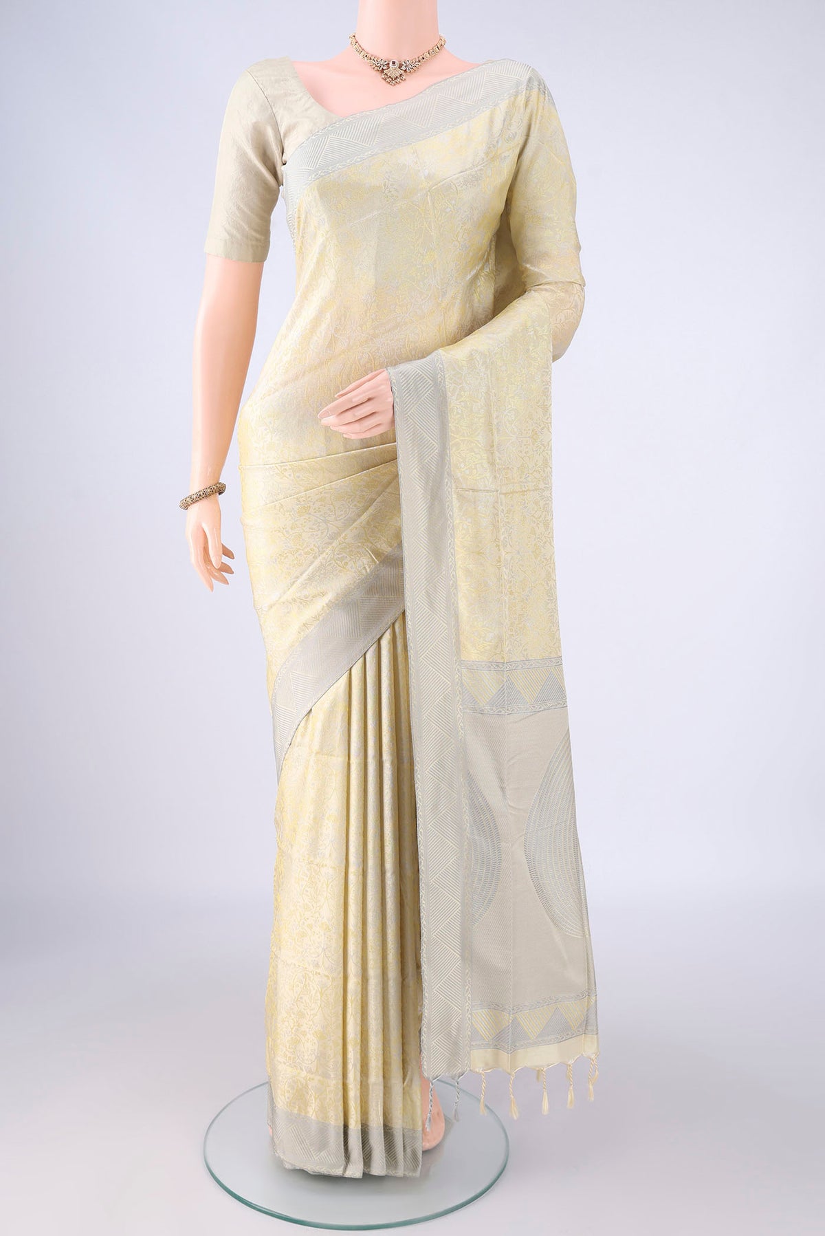 Cream Soft Silk Saree with Jacquard design on the body and Thread Border.  displayed on a mannequin