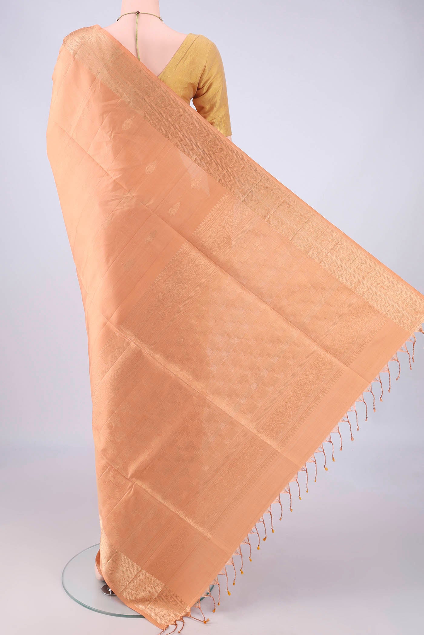 Flat view of Peach Soft Silk Saree with Zari Butta on the body and Zari Border. 