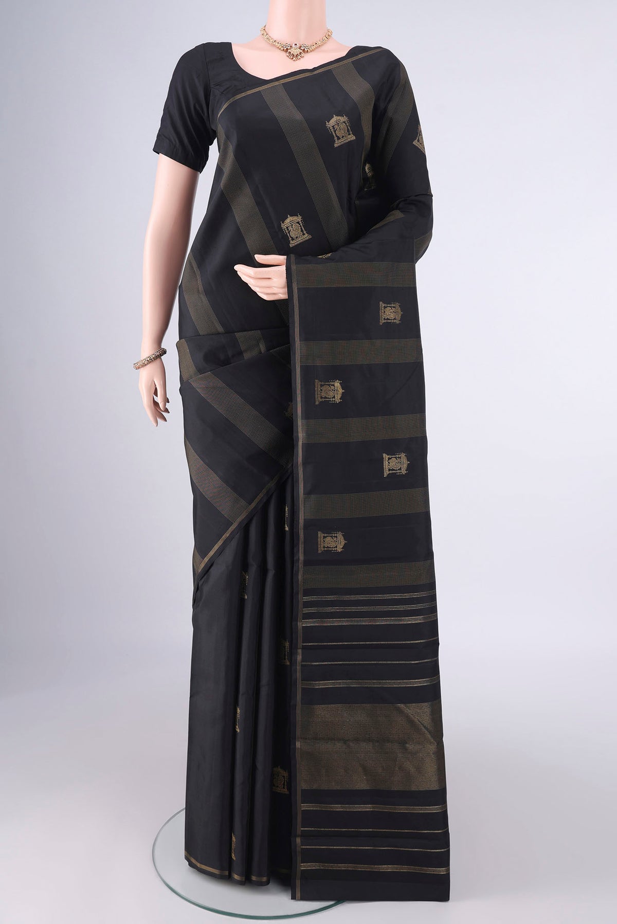 Pure Silk Pure Zari Black Kanjivaram Saree with Stripes on the body and Zari Border.  displayed on a mannequin