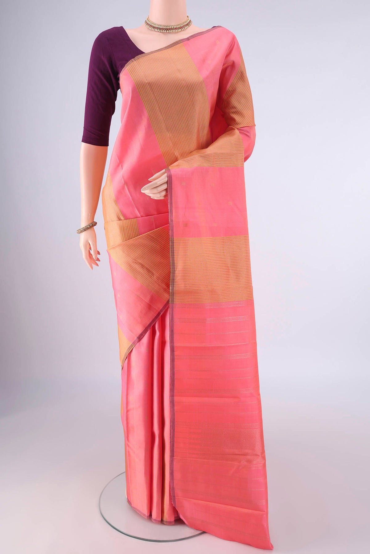 Pure Silk Coral Kanjivaram Saree with Stripes on the body and Without Border.  displayed on a mannequin