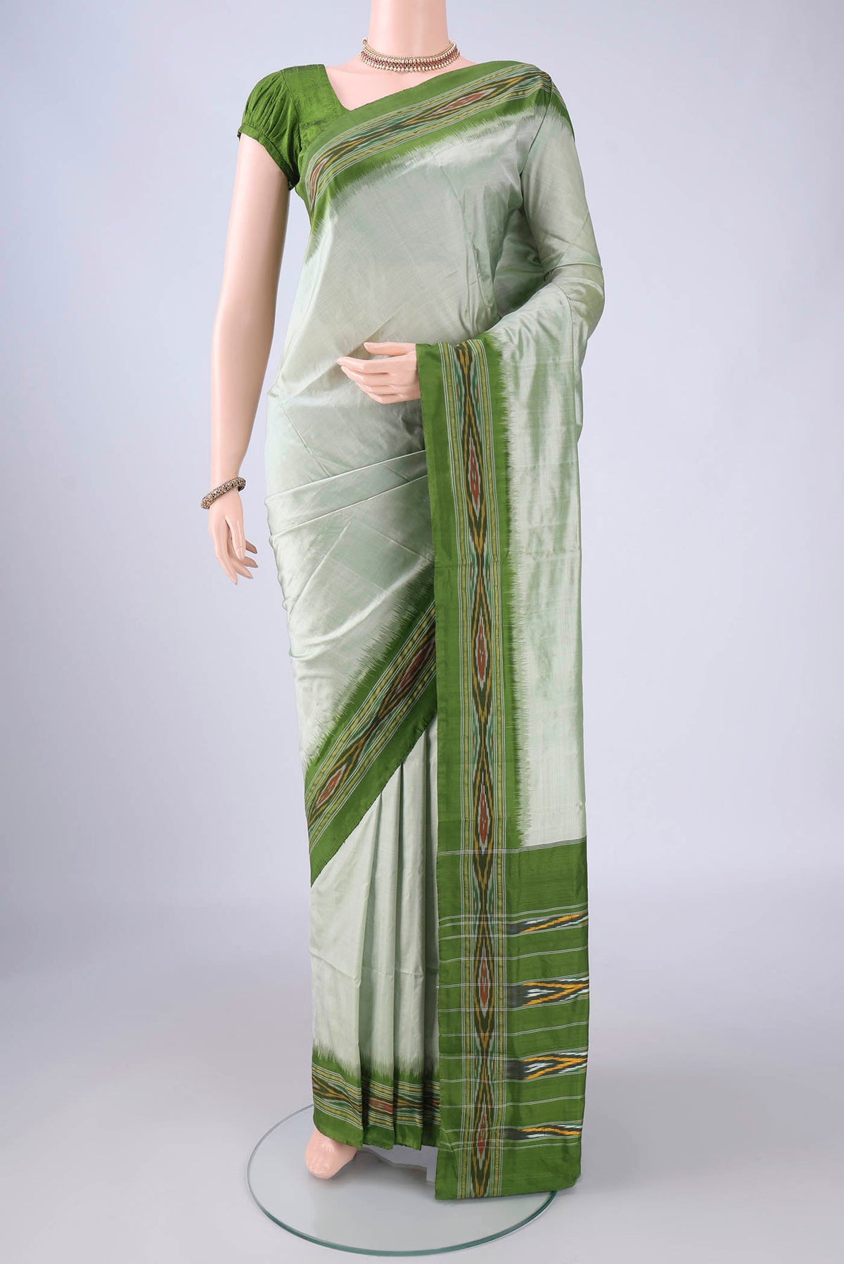 Sage Green Pochampally Silk Saree with Plain Body and Ikat Border.  displayed on a mannequin
