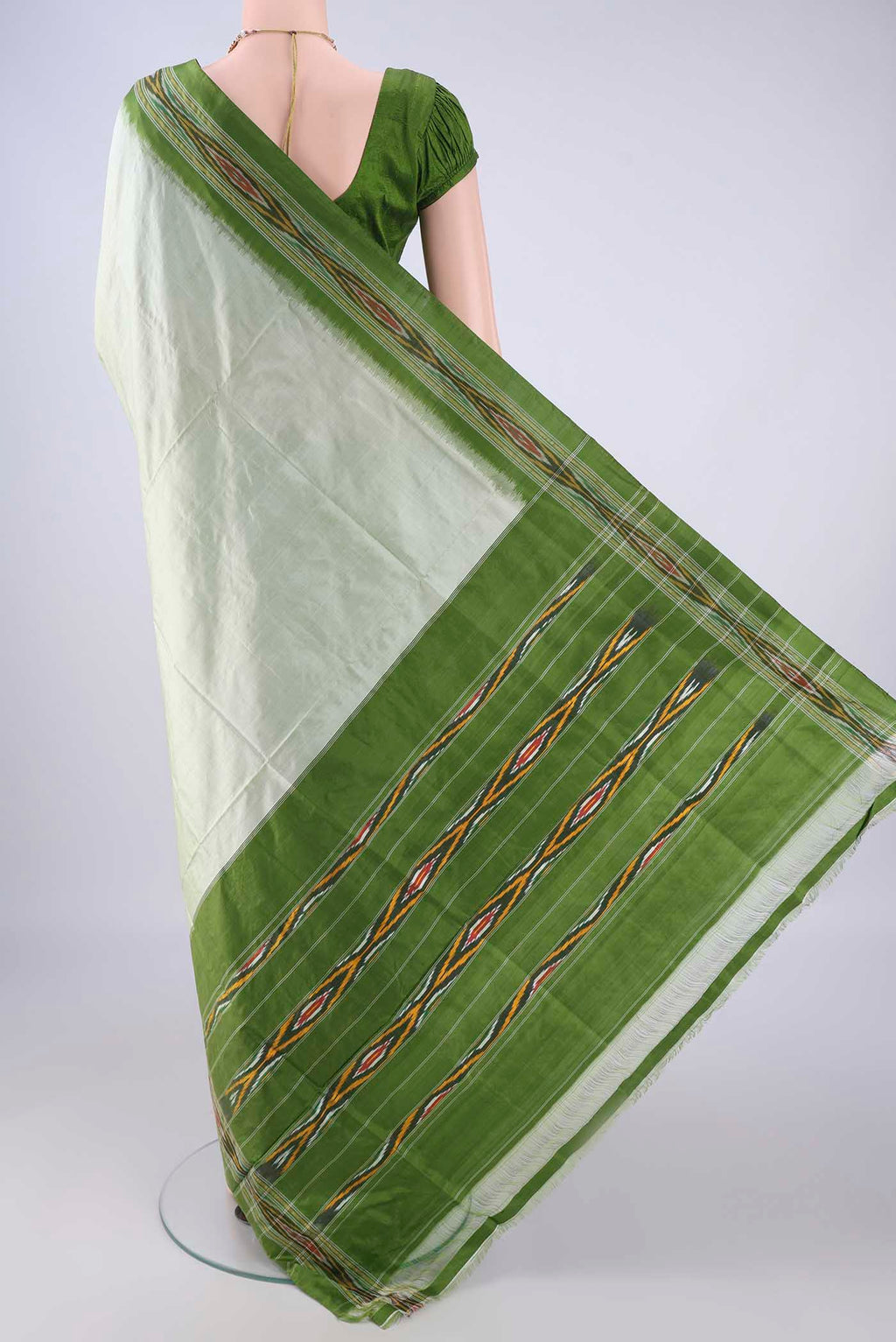 Flat view of Sage Green Pochampally Silk Saree with Plain Body and Ikat Border. 