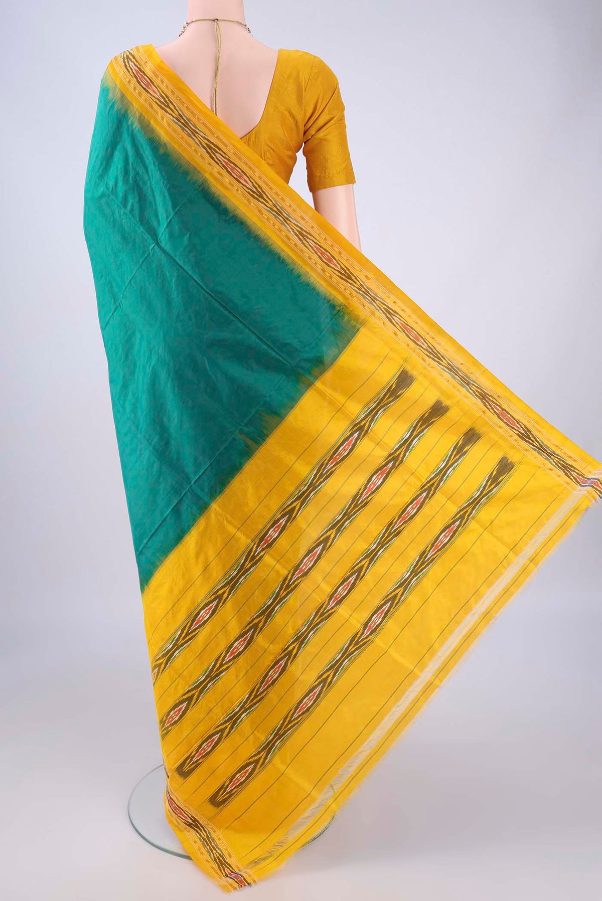 Flat view of Bottle Green Pochampally Silk Saree with Plain Body and Ikat Border. 