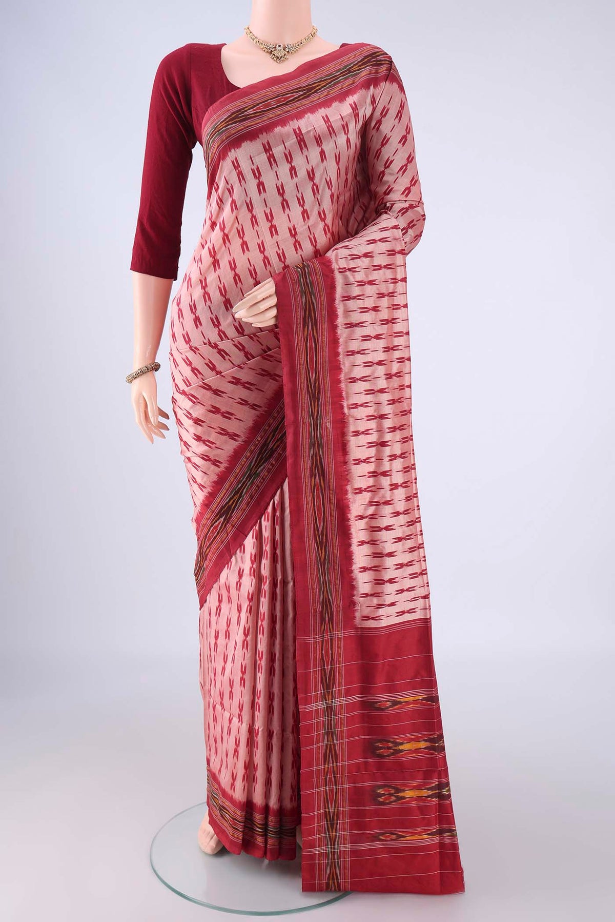 Peach Pochampally Silk Saree with Ikat design on the body and Ikat Border.  displayed on a mannequin